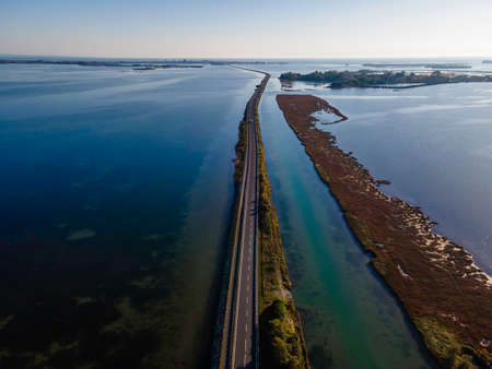 Aerial view of vehicles driving on a beautiful road crossing the lagoon in Grado near Gorizia, Friuli Venezia Giulia, Italy.の写真素材