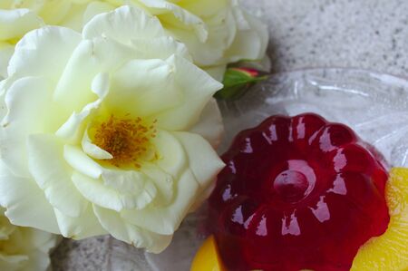 Red jelly with fruits and a white rose