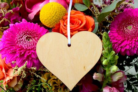Bunch of flowers and a wooden heartの写真素材