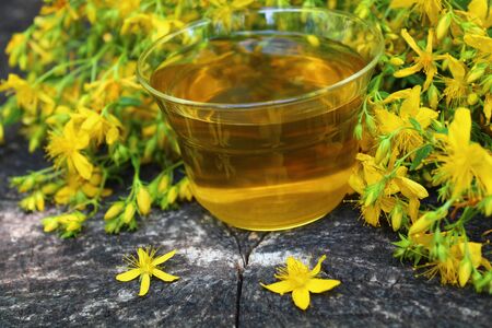 herb tea on an old weathered tree trunkの写真素材