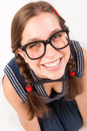 young goofy and nerdy girl looking at camera  studio shot の写真素材