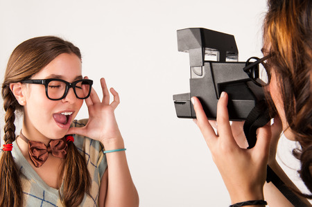 Young nerdy girls using instant camera  Studio shot の写真素材