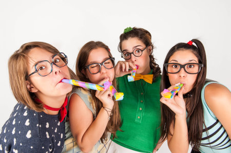 Group of friends blowing party horns  studio shot の写真素材