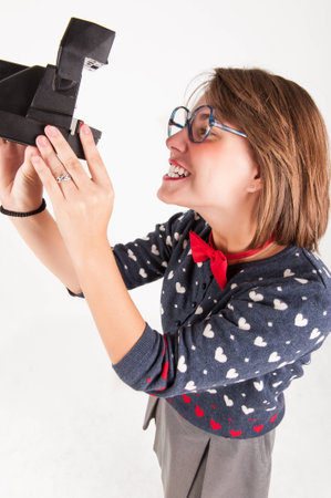 cute girl taking a picture with an instant camera  Studio shot の写真素材