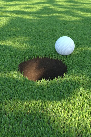 A white golf ball close to the holeの写真素材