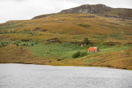 A small house on the shore of a lake in the Scottish Highlandsの写真素材