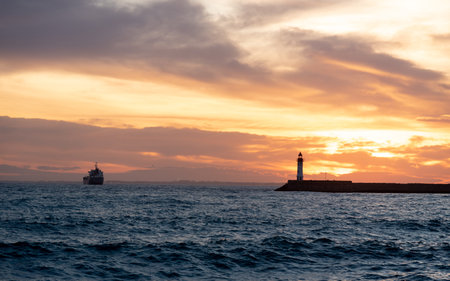 Lighthouse in the sea at sunset. Dramatic sky with clouds in Almeriaの写真素材