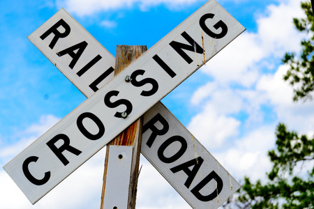 railroad crossing sign on a wood postの写真素材