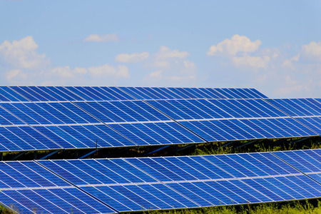 ground solar panels in a field under a blue sky