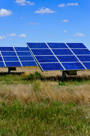 ground solar panels in a field under a blue sky