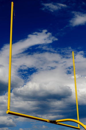 yellow goal posts agains cloudy blue skyの写真素材
