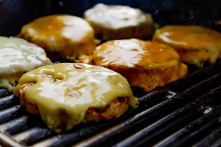 cheeseburgers cooking on the grillの写真素材