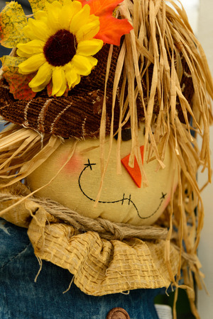 Halloween scarecrow decorations with flowers and hayの写真素材