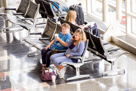 DCA, Reagan National Airport, Washington, DC - Passengers waiting in front of a bright interior airport windowのeditorial素材