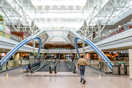 DIA, DEN, Denver International Airport, CO - Daylighting roof structure with people walking and people movers in an airportのeditorial素材