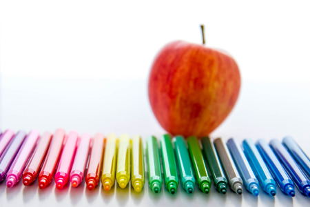 bright colored back to school supplies and an apple for the teacherの写真素材