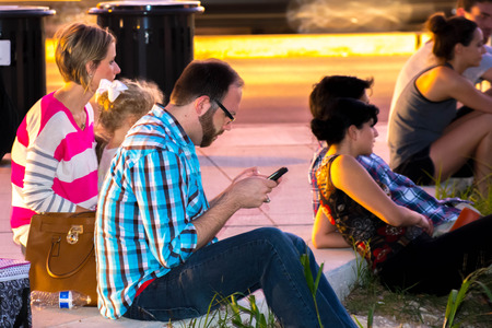 crowd sitting on a sidewalk waitingのeditorial素材