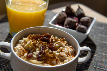 dried figs, oatmeal and orange juice breakfast settingの写真素材