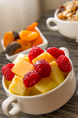 Fresh fruit and oatmeal with nuts and fruit toppings for breakfastの写真素材