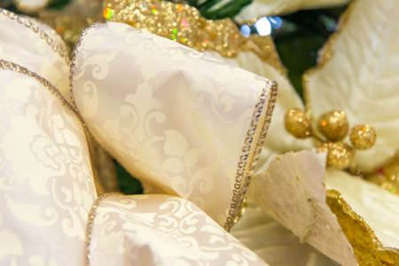 Holiday decorations - gold poinsettia with bowの写真素材