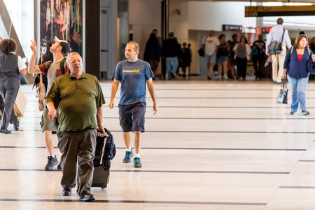 IAH, Houston Intercontinental Airport, Houston, TX, USA - passengers walking with lugagge in airportのeditorial素材