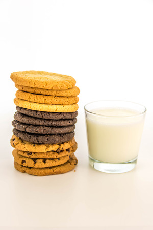 glass of milk and variety of cookies stackedの写真素材