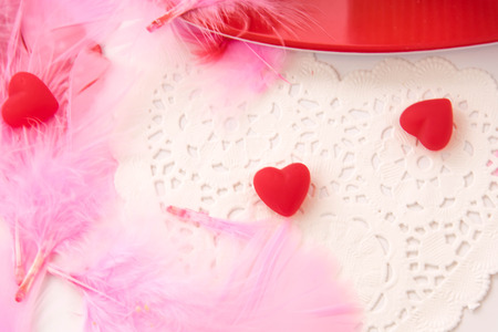 Valentines Day decorations, pink feathers and heart shaped candiesの写真素材