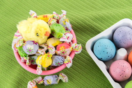 pastel colored Easter eggs, candy and yellow spring chick