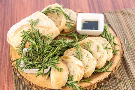 a fresh baked loaf of rosemary bread and olive oil and balsamic vinegarの写真素材