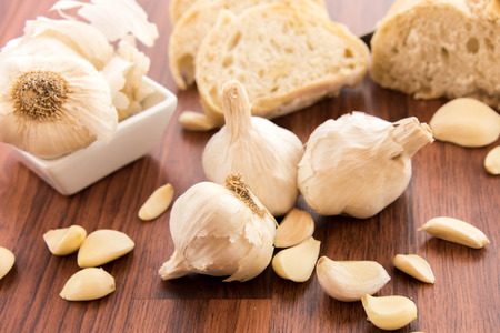 a fresh baked loaf of bread with whole cloves of roasted garlicの写真素材