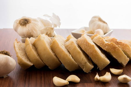 a fresh baked loaf of bread with whole cloves of roasted garlic