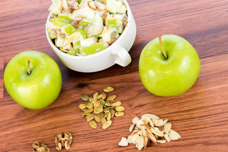 healthy snack: apple salad with almonds, walnuts and pumpkin seeds, condensed milk and lemon juiceの写真素材