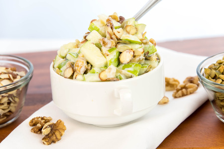 healthy snack: apple salad with almonds, walnuts and pumpkin seeds, condensed milk and lemon juiceの写真素材