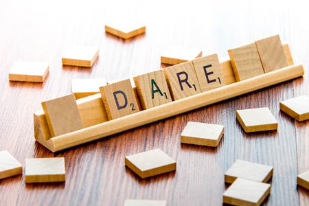 April 4, 2015:  Houston, TX, USA - Scrabble Word Game wood tiles spelling Dareのeditorial素材