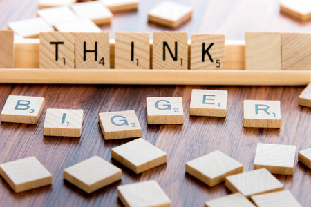 April 4, 2015:  Houston, TX, USA - Scrabble Word Game wood tiles spelling THINK BIGGERのeditorial素材