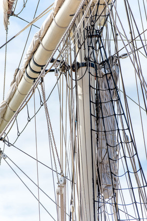 masts, rigging and rolled up sails of a tall sailboatの写真素材