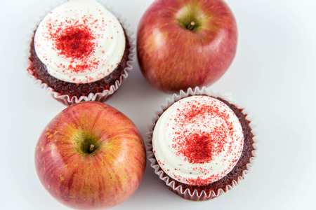 red apple vs red velvet cupcake - snack decision between healthy food or junk foodの写真素材