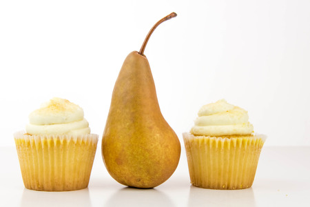yellow pear vs yellow cupcake - snack decision between healthy food or junk foodの写真素材