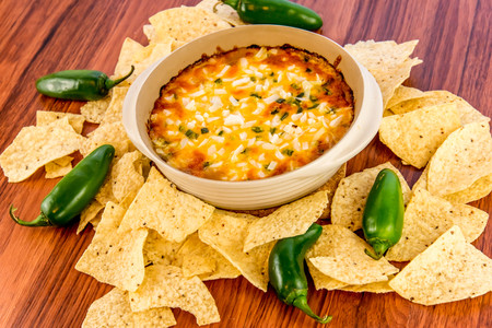 hot layered bean dip with jalapenos, sour cream and melted cheddar cheeseの写真素材