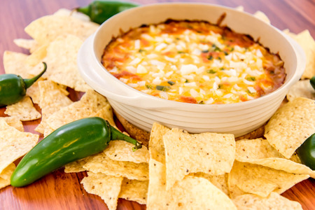 hot layered bean dip with jalapenos, sour cream and melted cheddar cheeseの写真素材