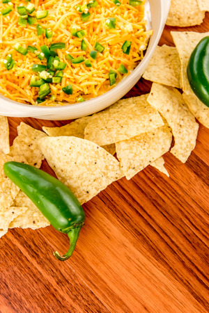 preparation of layered bean dip with jalapenos, sour cream and cheddar cheeseの写真素材