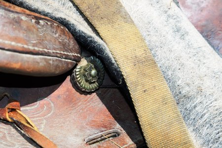 close up of a worn horse saddle stored in a barnの写真素材