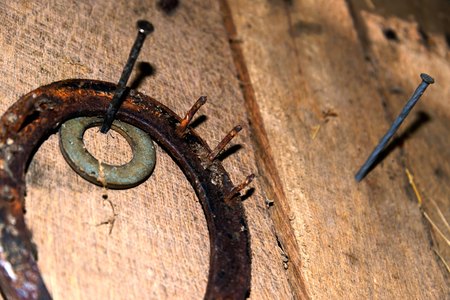 worn equestrian riding gear hanging in a barnの写真素材