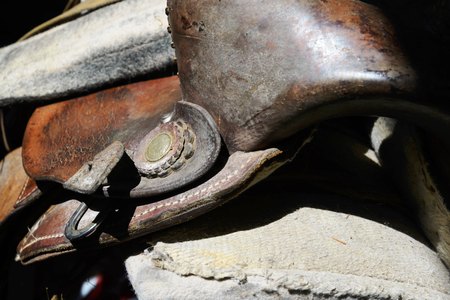 close up of a worn horse saddle stored in a barnの写真素材