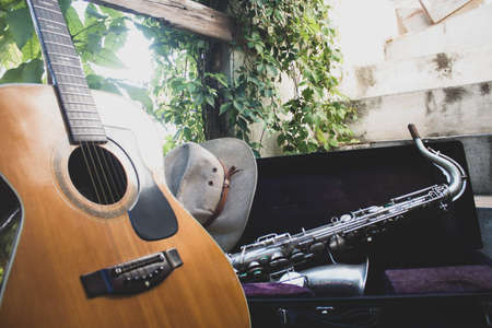 music on wood guitar and saxophone with blues country and jazz hat, vintage
