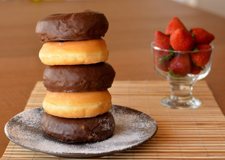 Stack Of Homemade Donuts On The Brown Plate And Fresh Strawberriesの写真素材