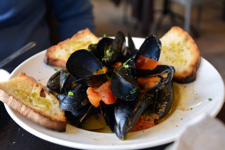 Steamed mussels on a white bowl on a tableの写真素材