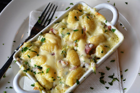 Gnocchetti with cheese baked on a white bowl on a tableの写真素材