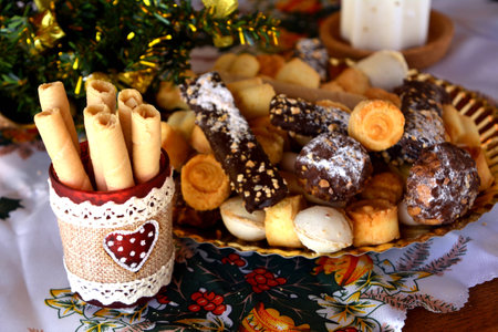 Christmas cookies on a plate and white lighted candleの写真素材