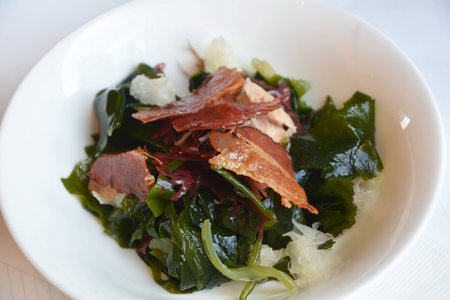 Japanese cuisine, delicious wasabi with bacon on a white bowl on a restaurant table.の写真素材